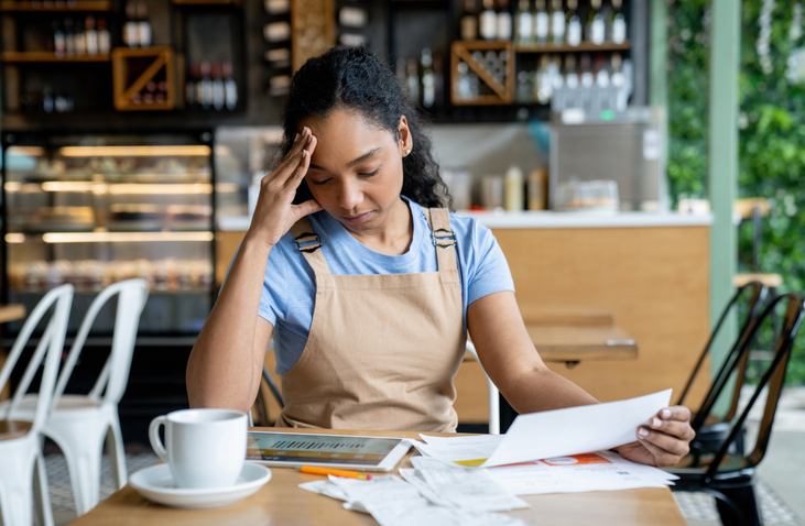 coffee shop owner stresses over documents