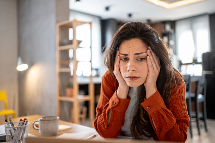 Stressed young woman working from home having problems